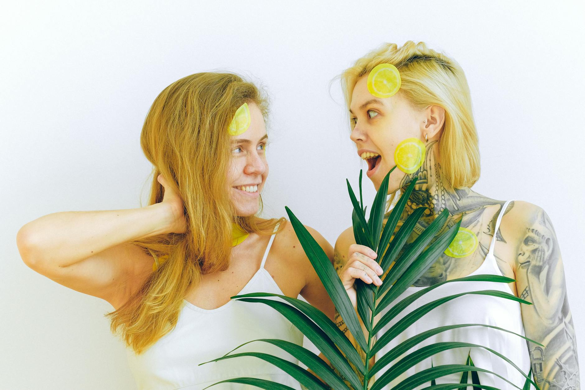 Two women laughing and enjoying time together with fresh lemons, expressing joy and connection