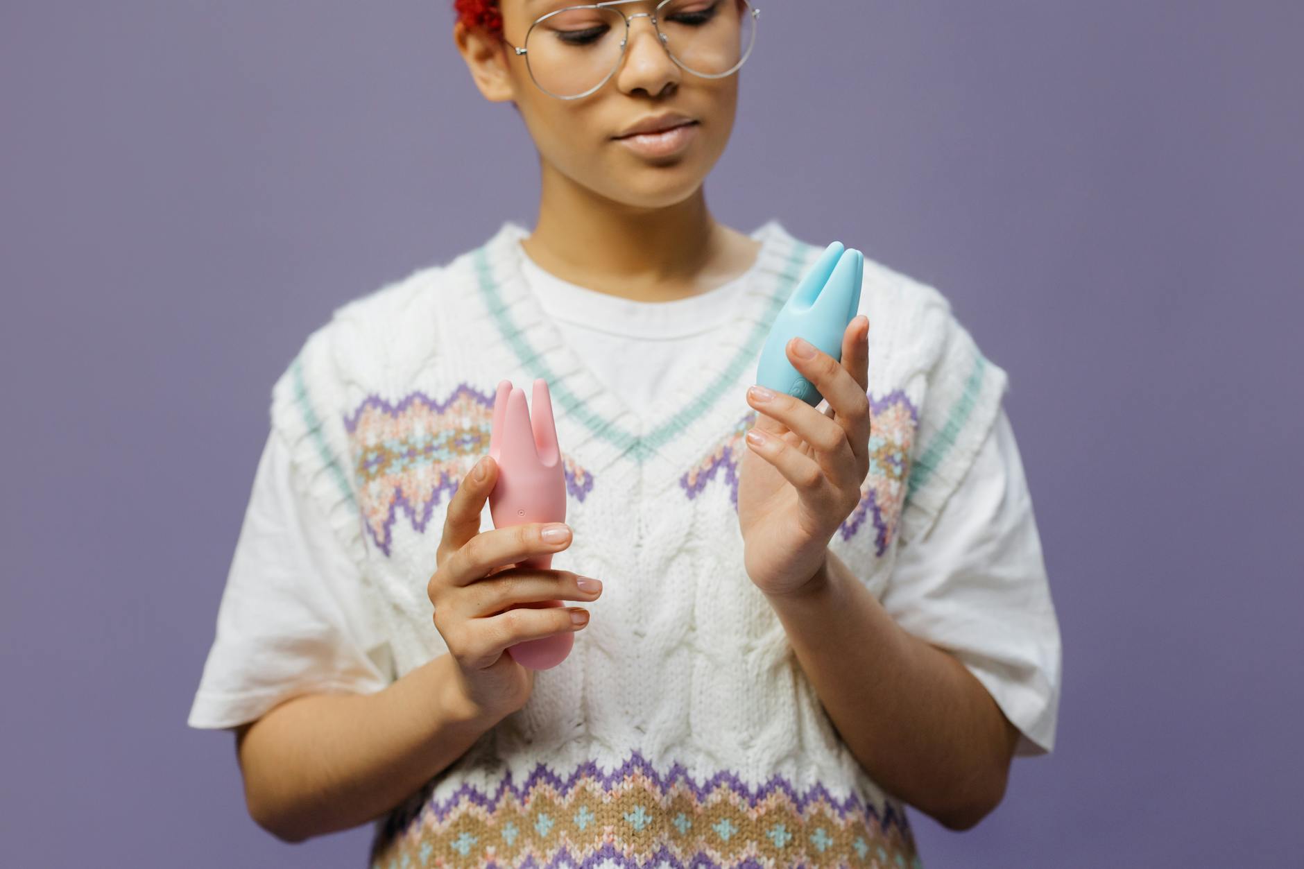 Two people holding modern silicone vibrators together, comfortable and smiling.