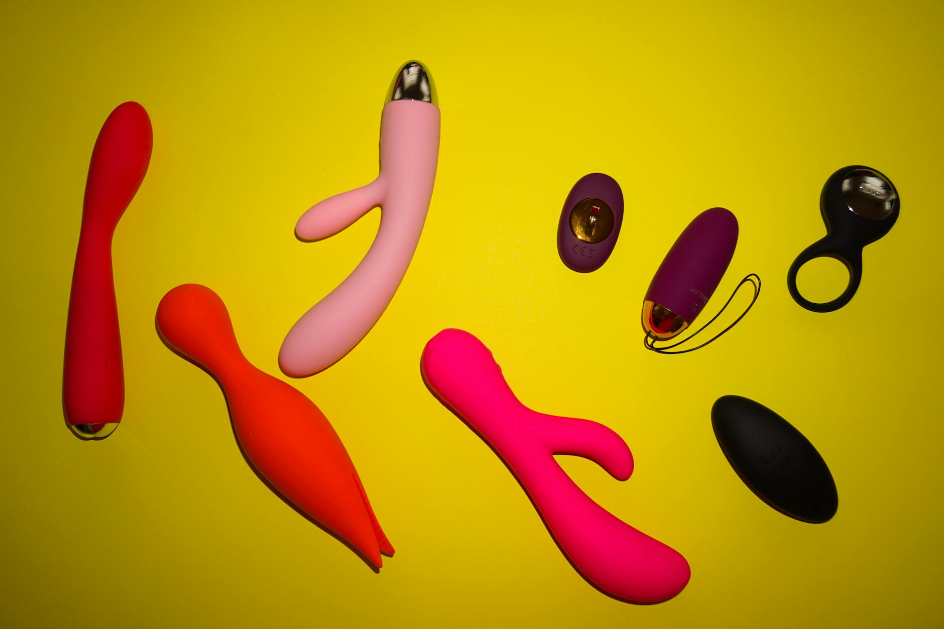 Close-up of a hand holding a vibrator against a minimalistic purple backdrop