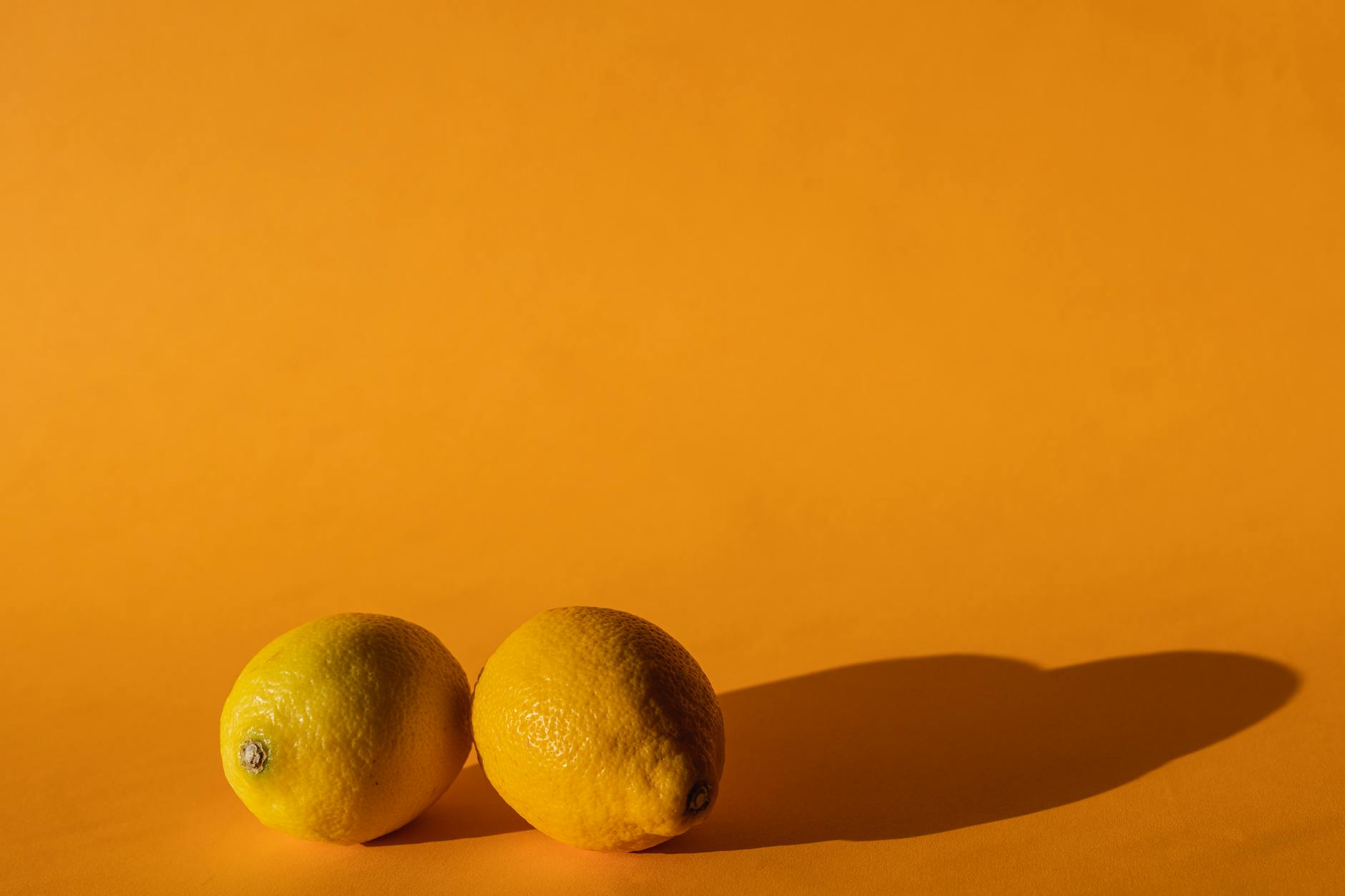 Vibrant fresh lemons arranged on a bright yellow background, symbolizing renewal and vitality